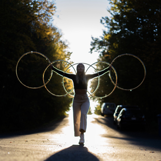 Une artiste de cirque forme un motif avec cinq hula hoops