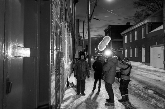 Équipe de tournage vêtue de manteaux dans une rue hivernale