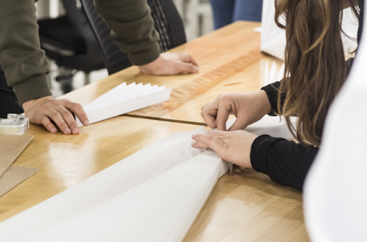 Des mains humaines manipulants des créations en papier