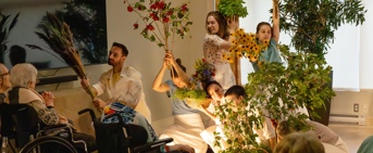 Des individus en performance de danse avec des fleurs dans une RPA