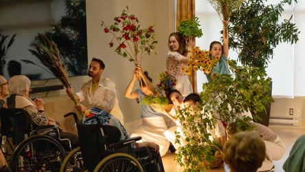 Des individus en performance de danse avec des fleurs dans une RPA