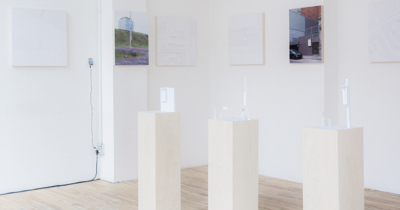 Une exposition d'items prototypiques sur trois petites colones rectangulaires blanches