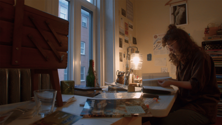 Une artiste qui feuillette un livre dans son atelier de création