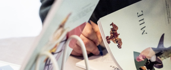 Une main signe une dédicasse dans un livre