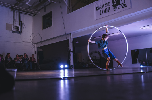 Femme debout au centre d'un hula hoop géant en mouvement rotatif