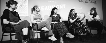 Cinq femmes assises lors d'un pannel, en boir et blanc