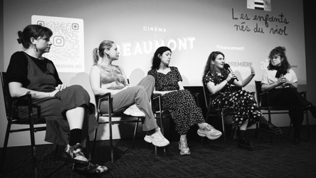 Cinq femmes assises lors d'un pannel, en boir et blanc