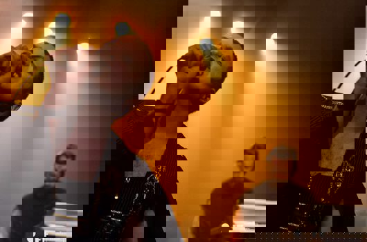 Un homme déguisé chante dans un micro qu'il tient, un musicien en arrière plan