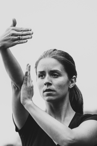 Une femme qui regarde à l'horizon avec les mains qui formes des signes