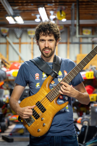 Homme debout tenant une guitare basse