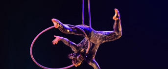 Une artiste circassienne en performance de cerceau aérien sur fond noir