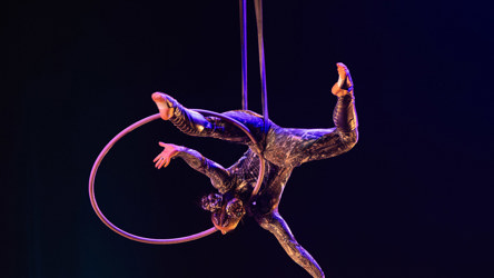 Une artiste circassienne en performance de cerceau aérien sur fond noir