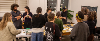 Des artisants réunits autour d'une longue table de travail