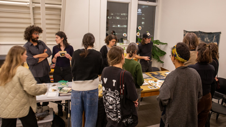 Des artisants réunits autour d'une longue table de travail